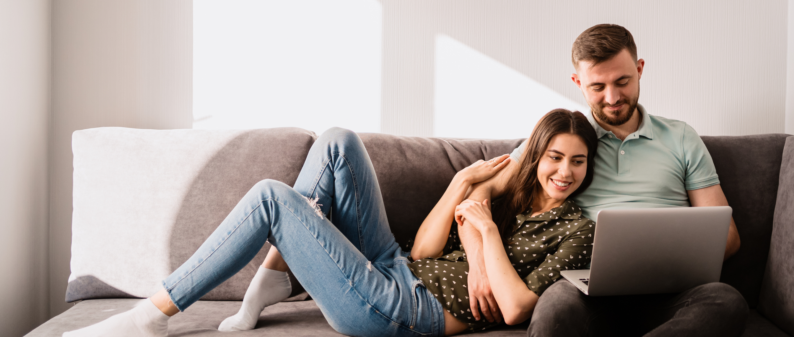 Man and woman sittin on a sofa with laptop